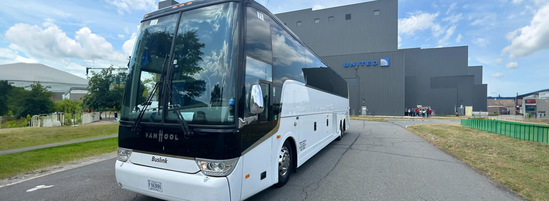 a white bus with a tall building behind