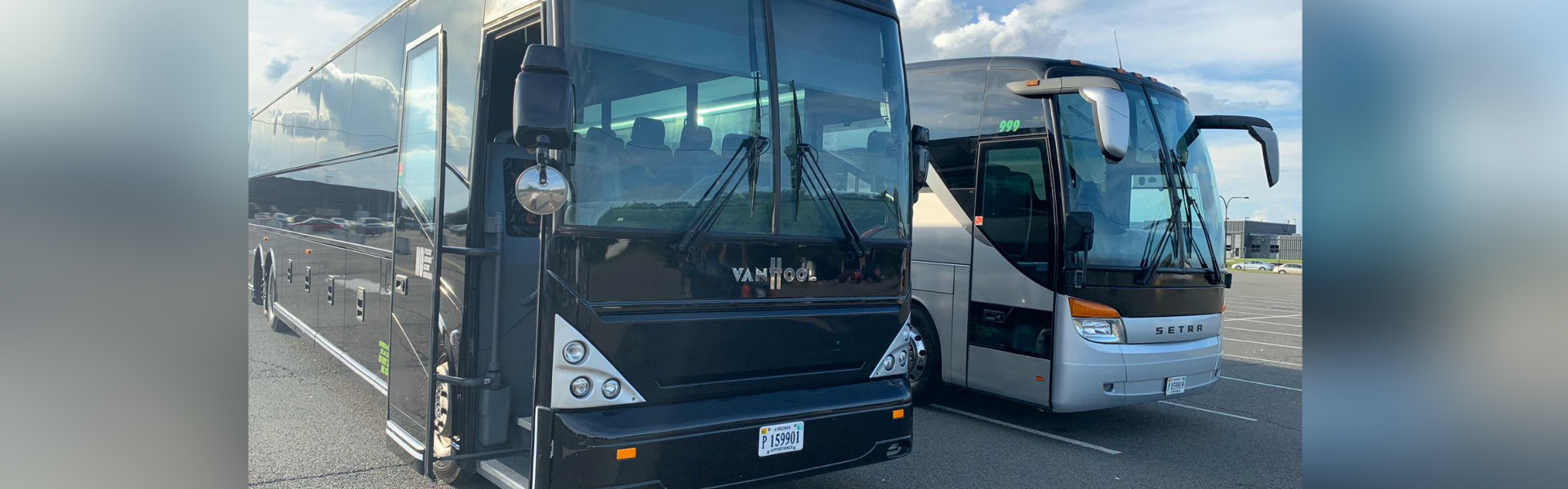 Two buses parked in a parking lot, ready to transport passengers