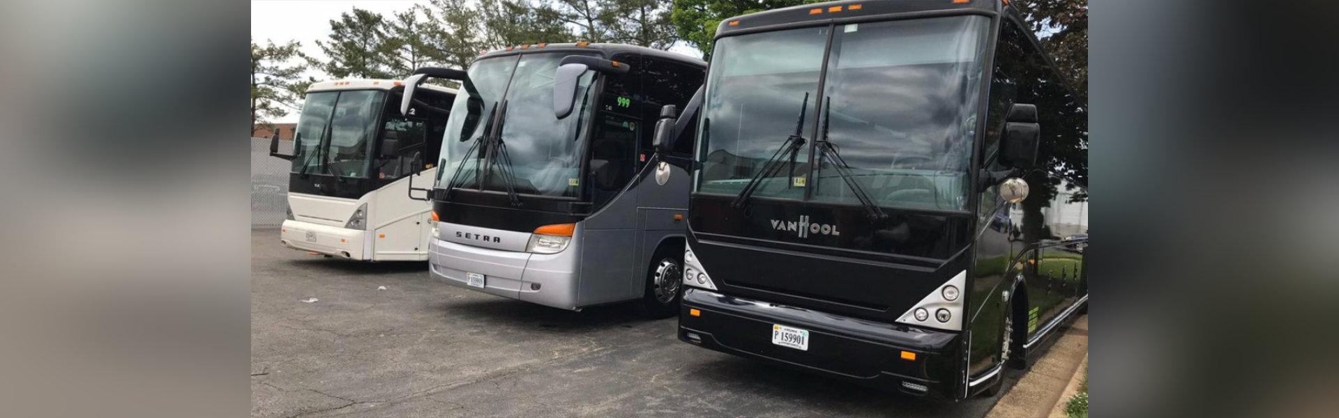 Three buses lined up in a parking area.